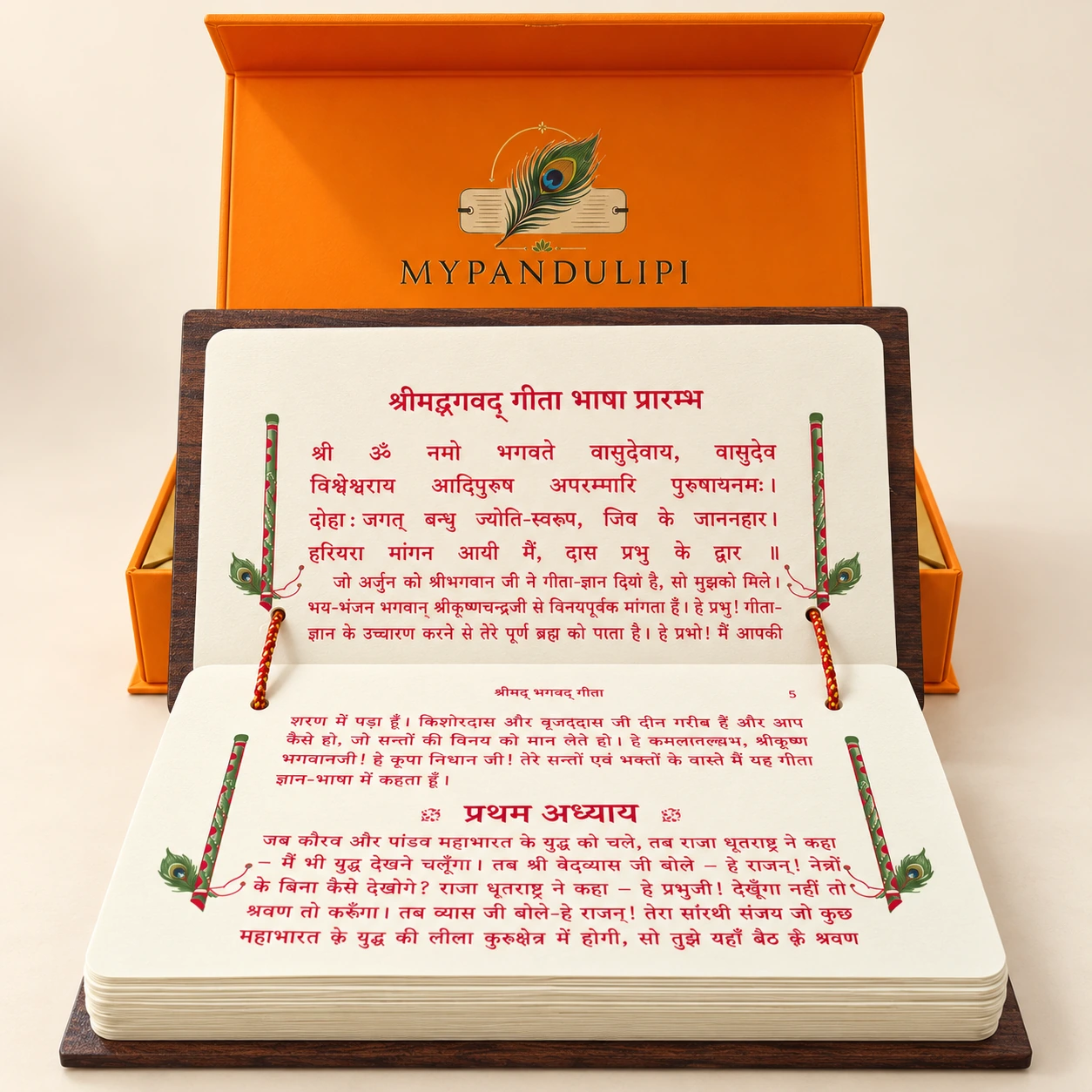 Bhagavad Gita pandulipi open to the first chapter in Hindi, with red text and decorative flute borders